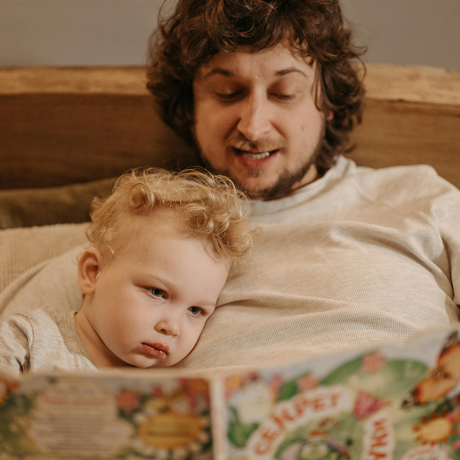 Stadtvorlesen. Papa liest seinem Kind vor.